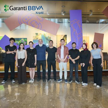 A group photo of eight people standing in front of a 'Garanti BBVA Kripto' logo in what appears to be a corporate lobby or office space.