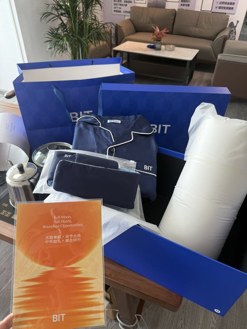 Photo of BIT university welcome gift bags and dorm supplies, including navy blue pajamas, bedding, and an orange folder labeled 'Fall 2026 Full Heart, Boundless Opportunities.'