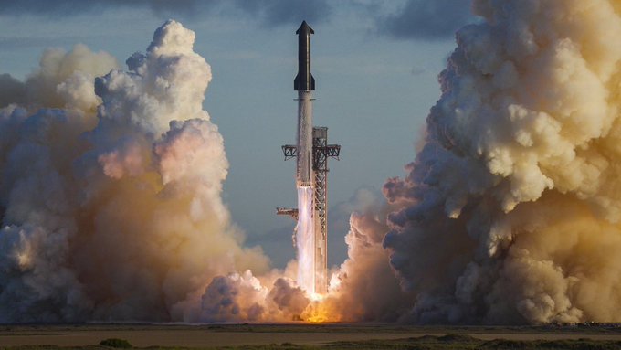 A rocket launches into the sky, surrounded by massive plumes of white and orange smoke and flames billowing on either side.