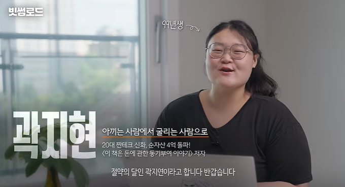 The image shows a young Korean woman with glasses smiling while sitting indoors, with Korean text overlay introducing "곽지헌" (Kwak Ji-heon), a 20-year-old fourth-year university student in the Department of Textiles and Consumer Science, whose dream catchphrase is "This is the story of someone who made 400 million won before turning 25."

The image relates to the post by showcasing a real example of a successful young entrepreneur whose achievements (making 400 million won before 25, registering real estate, writing books, buying Bitcoin) inspired the poster's motivation to start their own side hustle.