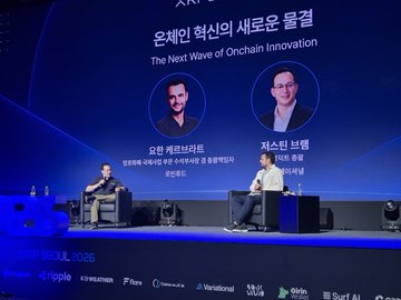 Two speakers sit on stage at the XRP Seoul 2026 conference for a fireside chat titled "The Next Wave of Onchain Innovation," featuring Johann Kerbrat (Robinhood) and a Variational representative, with logos for Ripple, Flare, Wormhole, Variational, Okto, and Swell visible along the bottom of the screen.