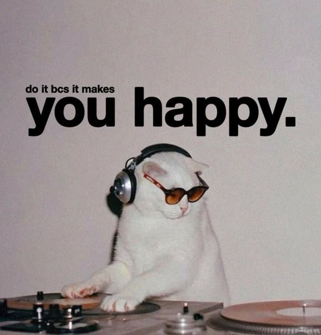 A white cat wearing sunglasses and headphones acting as a DJ, accompanied by the text 'do it bcs it makes you happy.'