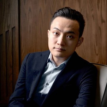 The image features a man wearing a suit, sitting down with his hands resting on his lap. The man has dark hair and is looking directly at the camera. In the background, there are wooden walls that add an elegant touch to the scene. There's also text in the image that reads "JUSTIN SUN-LINKED HTX DELISTS TRUMP FAMILY'S USD1 HTX", which seems to be related to a crypto exchange or cryptocurrency news. The man appears to be dressed for a formal event, and his attire suggests he might have some knowledge about the crypto world.