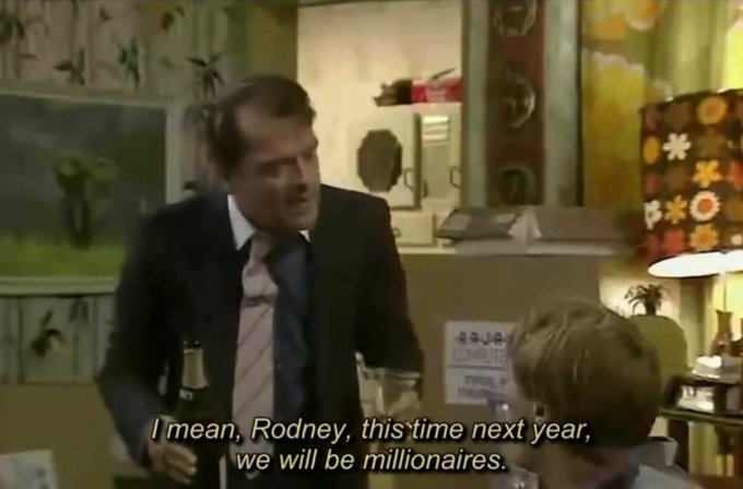 A scene from the British TV show 'Only Fools and Horses' featuring a man in a suit holding a beer bottle, with subtitles reading 'I mean, Rodney, this time next year, we will be millionaires.'