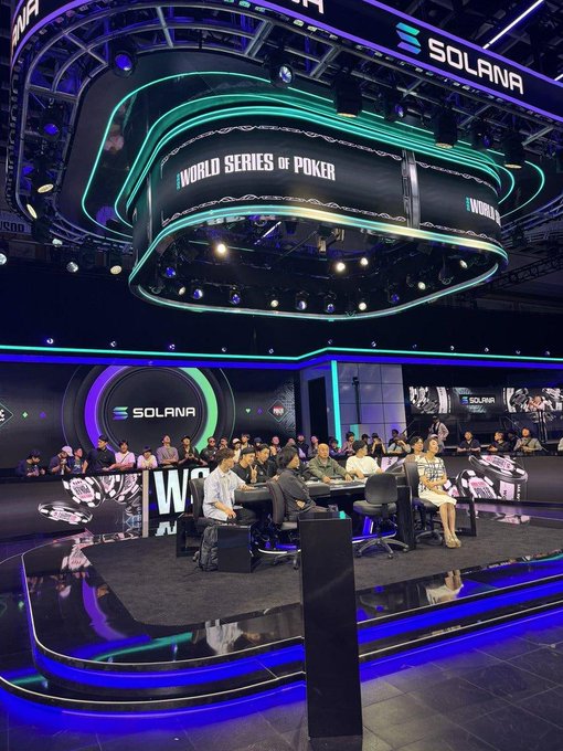 A photo of the World Series of Poker tournament floor with Solana branding prominently displayed on screens above the poker tables where players are seated and competing.