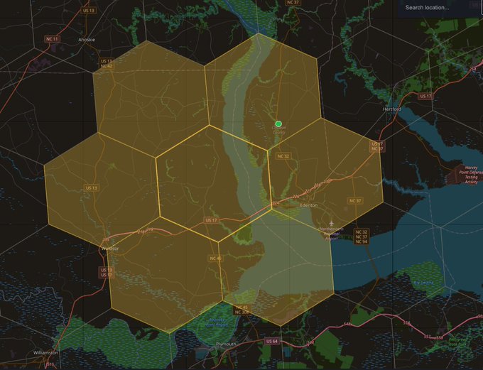 A dark-themed map interface showing the eastern North Carolina region with a hexagonal grid overlay in golden/orange tones, centered around cities including Plymouth, Edenton, and Williamston, with a search bar at the top.