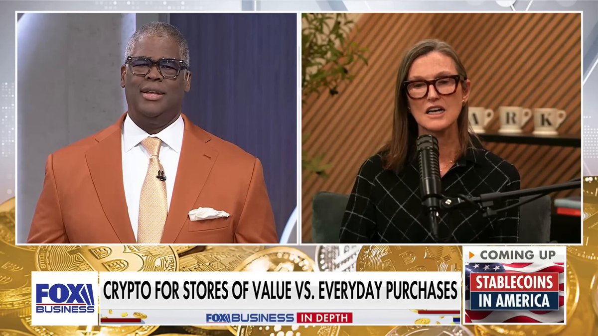 The image shows two men wearing suits talking into microphones while a banner with text above them reads "Crypto for stores of value vs everyday purchases" and below them, there are logos for Foxx and Ark Invest. The caption at the bottom of the image states that Bitcoin's supply is mathematically capped, and we see no reaction on the supply side. This information could be related to a discussion about the potential value of Bitcoin compared to gold or other assets in the current market conditions.