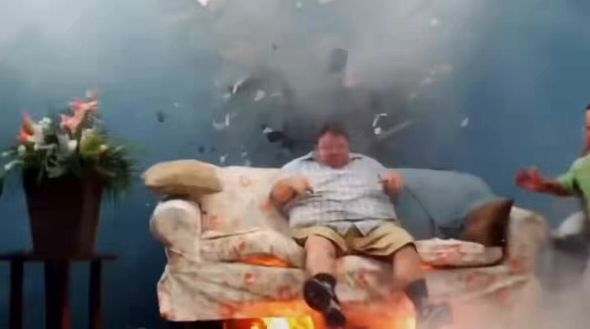The image shows a man sitting on a couch, with smoke coming out of his mouth. There are two people standing behind him, one on each side. A potted plant can be seen near the left edge of the frame, while another potted plant is located at the right side of the scene. The background features a blue wall and a brown table.

The post that says "XRP will go back up when the world stabilizes" suggests that there might have been an event or situation in the image that caused the smoke coming out of the man's mouth, possibly related to cryptocurrency or finance.