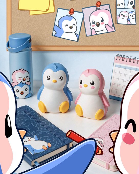 An advertisement featuring cute blue and pink penguin figurines displayed on a desk with a water bottle, notebook, and calendar decorated with matching penguin artwork.