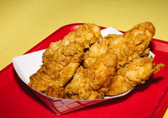 Two golden-brown churros dusted with cinnamon sugar sit in a white paper liner inside a red cardboard tray against a yellow surface. The image plays on "Bitboy Signal" as a visual pun—churros resembling candlestick charts or signal bars, possibly suggesting a bullish price signal for a cryptocurrency called "Bitboy."