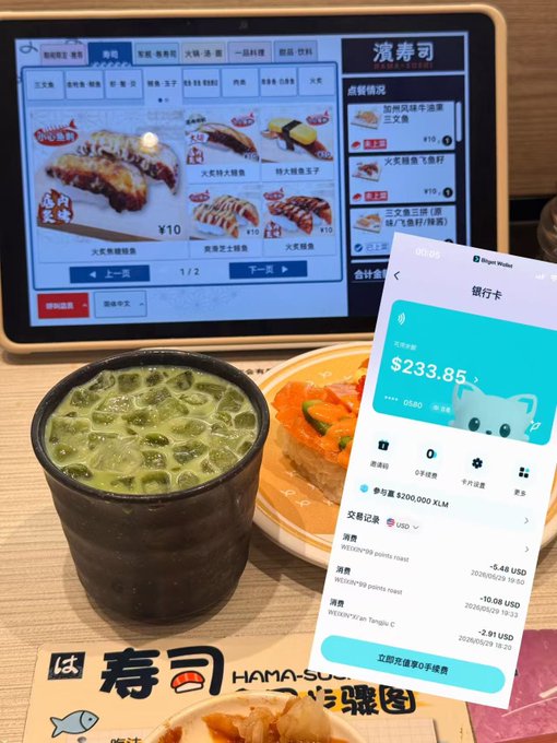 The image shows a table with various food items, including sushi rolls, a cup of green tea, and a cell phone displaying a payment app. The cell phone screen displays information about a cryptocurrency called "U-Coin" that can be used for purchases or transactions. The text on the cell phone suggests that it is a survival plan designed to help users navigate the challenges of using cryptocurrencies in their daily lives.