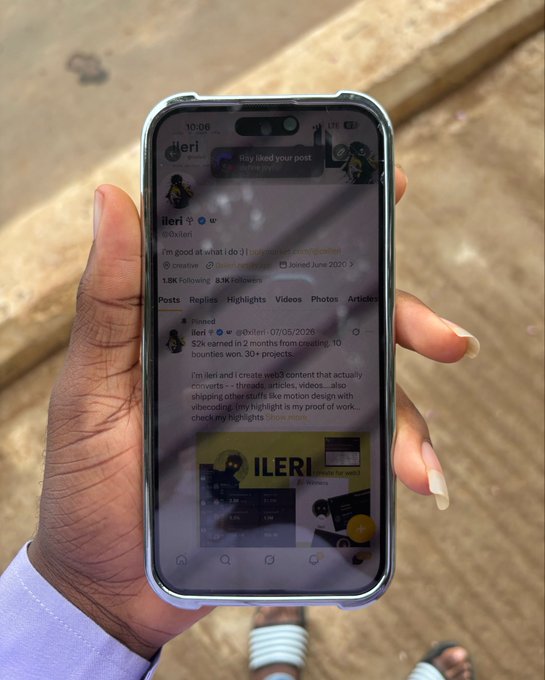 A hand holds a smartphone displaying the Twitter/X profile of "ileri" (@0xIleri), featuring a pinned post from July 5, 2026, that promotes freelancing services offering 2 months of credits for 10 bounties and 30+ completed projects. The profile, which the accompanying post mentions will be actively used for tweeting, showcases the creator's portfolio including web design and motion work samples.