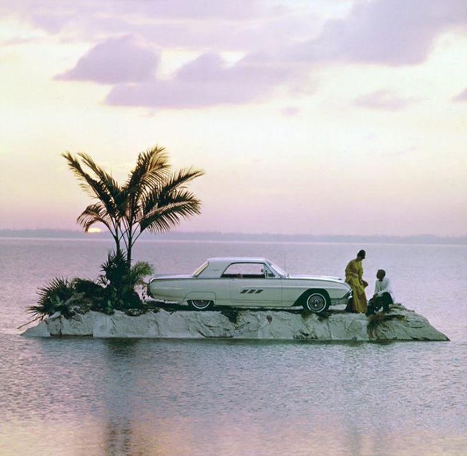 The image features an old white car parked on a rock in the middle of a body of water, with two people standing nearby. The scene appears to be set during sunset or dusk, adding a serene atmosphere to the location. The caption "gm ct it's a beautiful new week what are we building on @arc this week?" suggests that the image might have been taken at the beginning of the week when people often take time off work to enjoy outdoor activities and appreciate nature.

The car is parked in front of a palm tree, which adds an interesting contrast between the man-made object and the natural environment surrounding it. The two people standing nearby seem to be enjoying their time together near the water's edge or on the rock, possibly taking a break from their daily routines to appreciate the beauty of the scene.