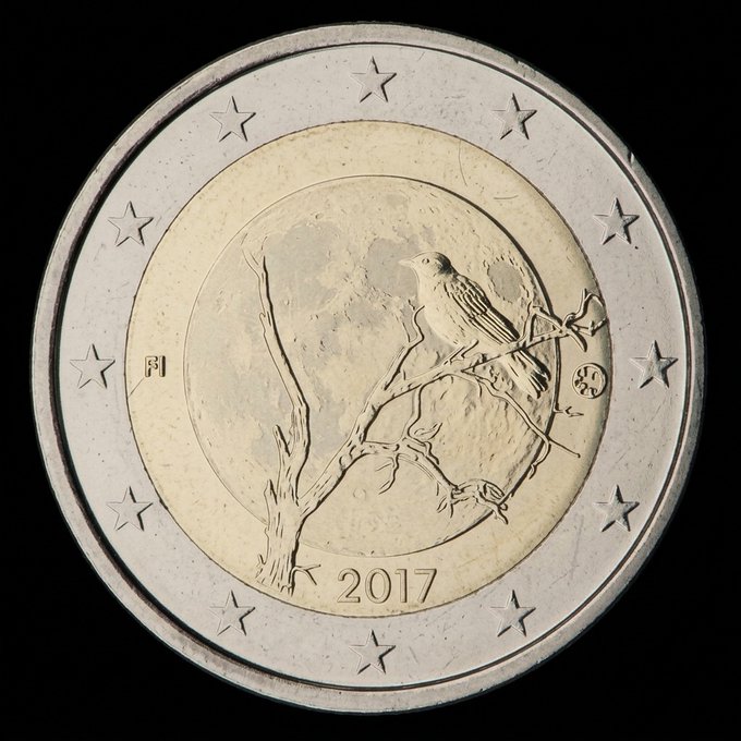 A close-up photograph of a 2017 Finnish 2 euro commemorative coin featuring a bird perched on a branch under a moon, displayed against a black background, likely promoted as a collectible item for numismatic or NFT collectors.