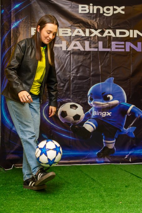 A woman poses with a soccer ball in front of a BingX-branded banner featuring a dolphin mascot, with visible text reading "BingX" and "BAIXADA HALLEN," tying into the post's celebration of community and football passion at the Floripa event.