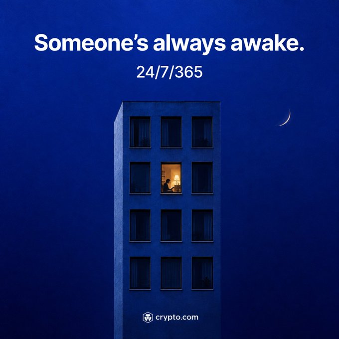 A lone lit window in a dark blue apartment building against a night sky with a crescent moon accompanies the text "Someone's always awake. 24/7/365" and the crypto.com logo, visually reinforcing the message that while some sleep, others are starting or ending their day—mirroring the always-on nature of the crypto market across global time zones.