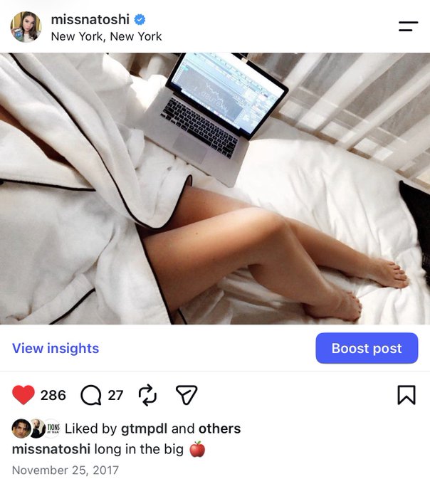 A woman relaxes in bed with a laptop displaying trading charts, captioned "long in the big 🍎" by missnatoshi, tying into the post's theme of taking a 100X long position with a casual, carefree attitude despite the "RIP Bitmex" reference to leveraged trading risk.
