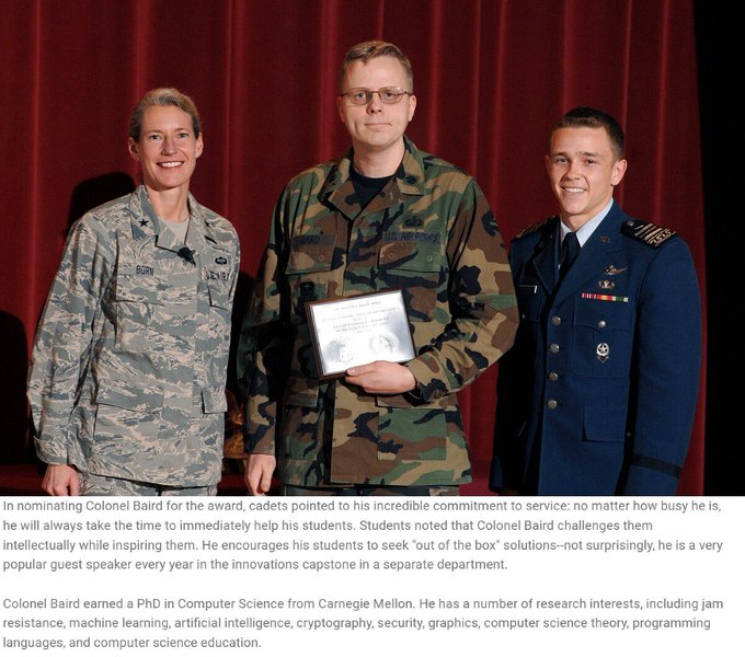 Photo of three military personnel, including Colonel Baird in the center holding an award certificate, with a caption detailing his dedication to cadets and his PhD in Computer Science from Carnegie Mellon.