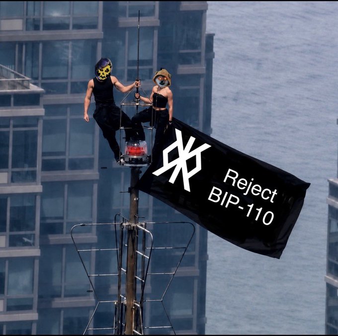 Two masked protesters perch atop a broadcast antenna holding a black banner reading "Reject BIP-110" with a stylized logo, with water and high-rise buildings visible in the background.