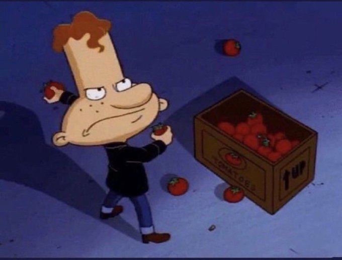 An animated cartoon character with orange hair angrily clutching tomatoes, standing next to a wooden crate labeled 'TOMATOES' with arrows pointing up.