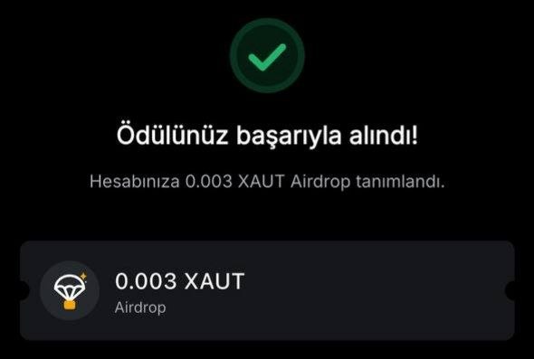 A dark screen with a green checkmark displays a Turkish message 'Ödülünüz başarıyla alındı!' confirming that 0.003 XAUT Airdrop has been credited to the account.