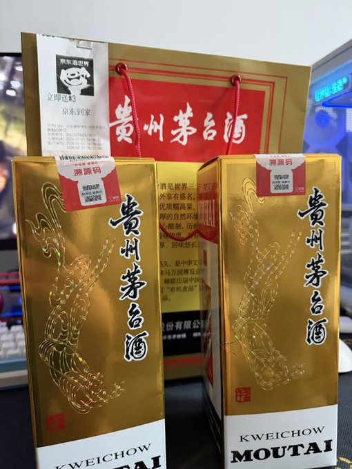 Bottles of 'Kweichow Moutai' Chinese liquor in gold boxes and a red shopping bag, with a JD.com (京东) delivery tag attached.