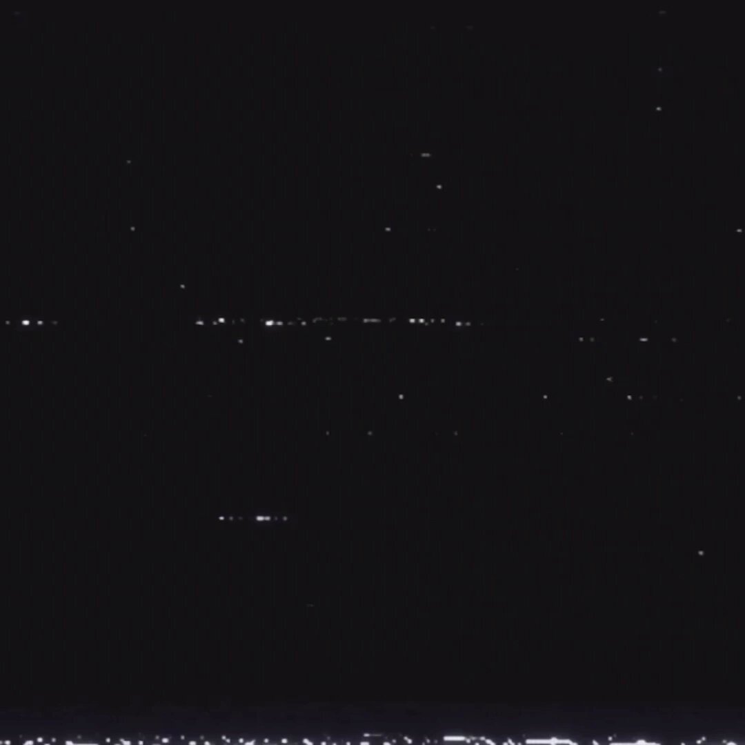 The image shows a night sky with numerous stars scattered across it. There are also some lights visible in the background that appear to be coming from an auction or event taking place at NODE, as indicated by the caption "An Alien is landing at NODE. Onchain auction, June 25". The focus of the image is on the stars and their arrangement in the sky, with the additional context provided by the caption.