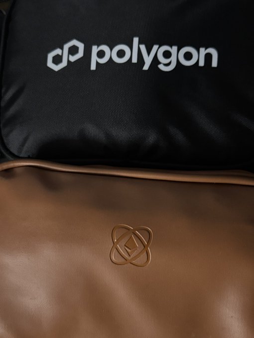 A black backpack displays the white "polygon" logo and text, with a brown leather pouch below featuring an embossed emblem.