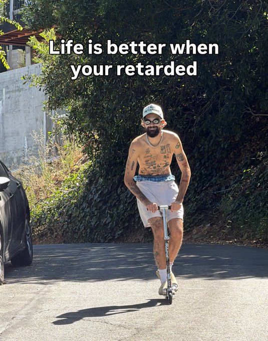The image shows a shirtless, tattooed man wearing a cap and sunglasses riding a scooter on a driveway, with overlaid text reading "Life is better when your retarded." Given the post's context of "SOLANA SUMMER," the carefree, playful scene appears to embody the lighthearted, meme-driven spirit of the crypto community.
