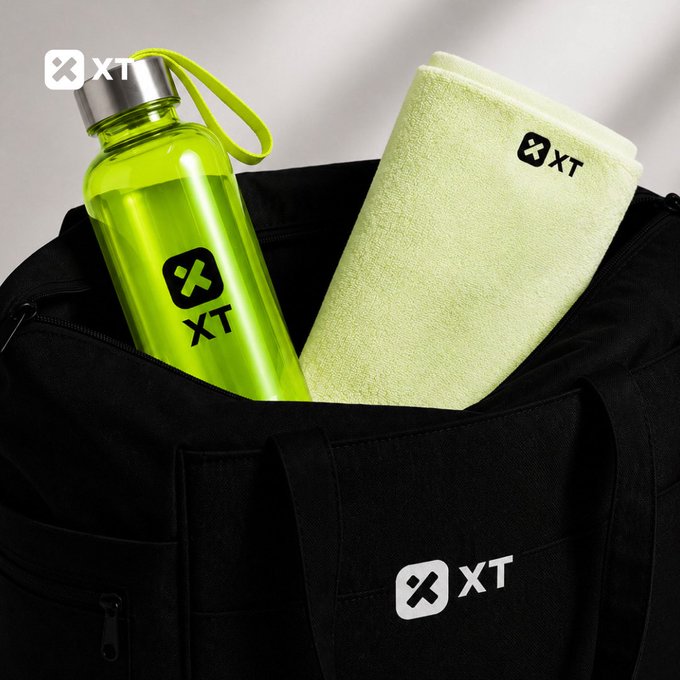 A promotional image showing a neon green XT-branded water bottle and a folded XT towel tucked into a black XT-branded duffel bag.