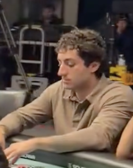 A screenshot of Mark Zuckerberg in a tan polo shirt operating a control panel in what appears to be an industrial setting.