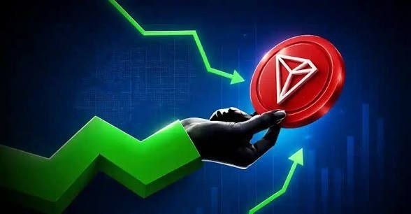 A hand holds a red TRON (TRX) cryptocurrency coin against a blue background with a rising green chart and arrow, symbolizing growth.