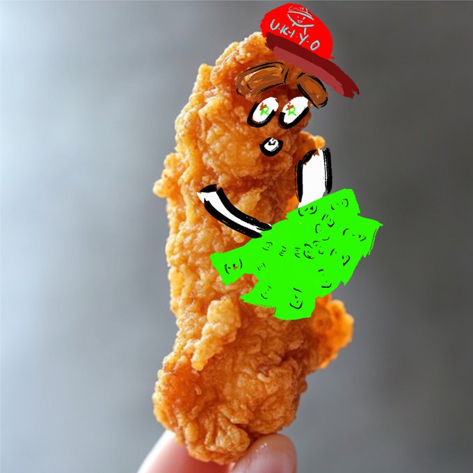 A piece of fried chicken has been digitally drawn over with a cartoon face wearing an Ukiyo-e hat and a green skirt.