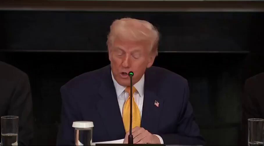 The image shows a man sitting at a table, wearing a suit and tie, with his hands clasped together as he speaks into a microphone. The text "BREAKING: PRESIDENT TRUMP SAYS THE U.S. MADE A MASSIVE MISTAKE BY SELLING TENS OF THOUSANDS IT'S BITCOIN HOLDINGS WERE WORTH BILLIONS MORE TODAY" is displayed, indicating that the man is giving a speech or addressing an issue related to Bitcoin and its value.

The image also includes several cups placed on the table in front of the man, suggesting that he might be at a gathering or event where refreshments are being served.