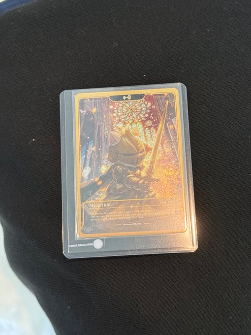 A single trading card rests on a black fabric surface, displayed in a protective sleeve. The card features an illustration of a knight in armor holding a sword against a stained glass window background, with visible text reading "Mystic #66" at the bottom, connecting to the "mlmabc" card pull referenced in the post.