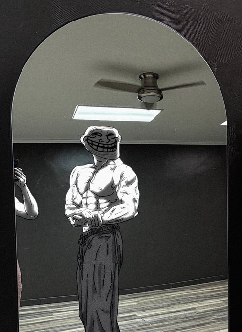 A black-and-white illustration depicts a muscular man with the troll face meme for a head, posing with crossed arms in front of a mirror, while holding a phone.