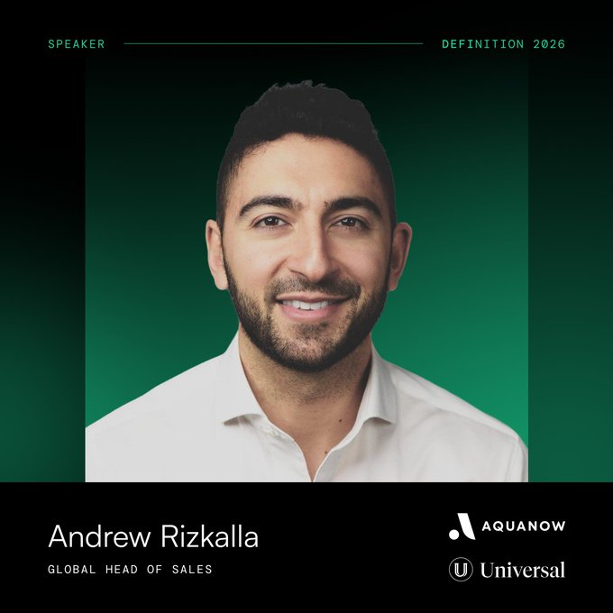A professional speaker portrait card for 'Andrew Rizkalla, Global Head of Sales' at Universal Music/AquaNow for the 'Definition 2026' event, showing a smiling man with a beard in a white shirt against a green background.