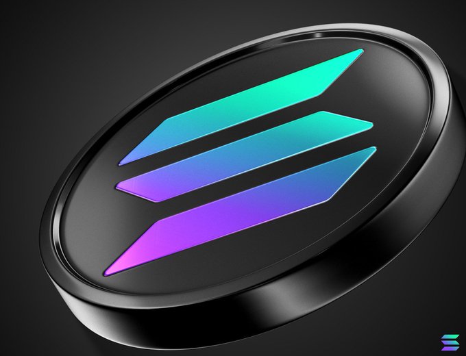 A sleek metallic coin or token featuring the Solana logo with its signature teal-to-purple gradient stripes on a dark background.
