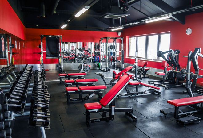 A modern, fully-equipped gym with red and black decor, featuring dumbbells, weight benches, squat racks, and a large mirror reflecting various exercise machines.

The image relates to the post by visually representing the "time to get back to work" message through a gym setting, symbolizing personal discipline, fitness goals, and a return to routine after the weekend—though the gym focus contrasts with the post's primary theme of NFT giveaways.