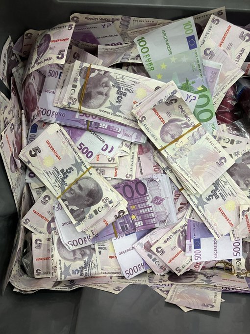 A pile of bundled Turkish Lira banknotes in denominations of 5, 10, 100, and 500, including stacks banded with rubber bands featuring portraits of Mustafa Kemal Atatürk.