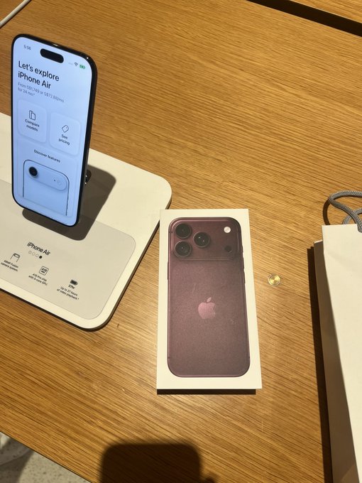 A "Let's explore iPhone Air" display stand and a burgundy iPhone Pro box sit on a wooden table at what appears to be an Apple Store, with the cashback caption referencing the recent purchase shown.