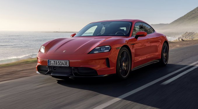 A red Porsche Taycan with the German license plate "S TA 5143E" speeds along a coastal road, with misty mountains in the background. The post suggests the user is on the verge of achieving their dream of owning such a luxury sports car.