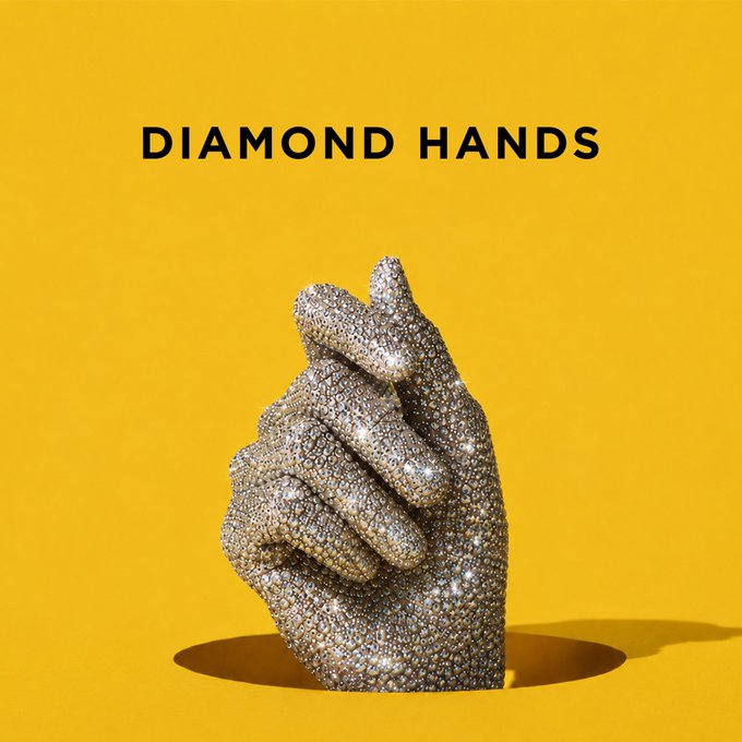 A sculptural hand encrusted with sparkling diamonds emerges from a hole against a solid yellow background, with the bold text 'DIAMOND HANDS' above it.