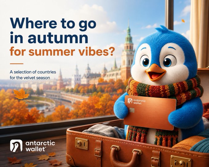 Travel advertisement for 'Antarctic wallet' featuring a 3D-rendered blue penguin wearing a scarf in a suitcase, with text 'Where to go in autumn for summer vibes? A selection of countries for the velvet season' against a European city backdrop.