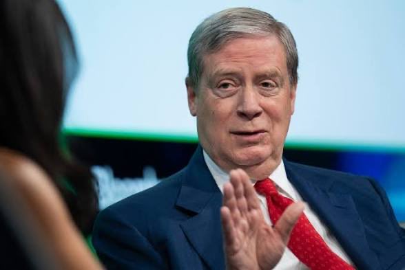 Stanley Druckenmiller, dressed in a navy suit and red tie, gestures while speaking at what appears to be a televised interview or panel discussion.

The image shows Stanley Druckenmiller engaged in conversation, likely referencing his ongoing public debates and commentary on fiscal policy, particularly his criticism of Treasury intervention and government deficits discussed in the post about his alleged feud with Bessent.