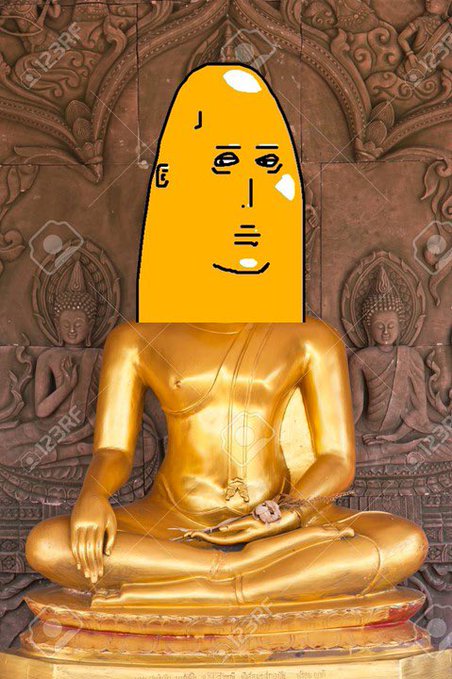 A golden Buddha statue has a crudely drawn yellow face doodled over its head, placed against an intricately carved wooden background.