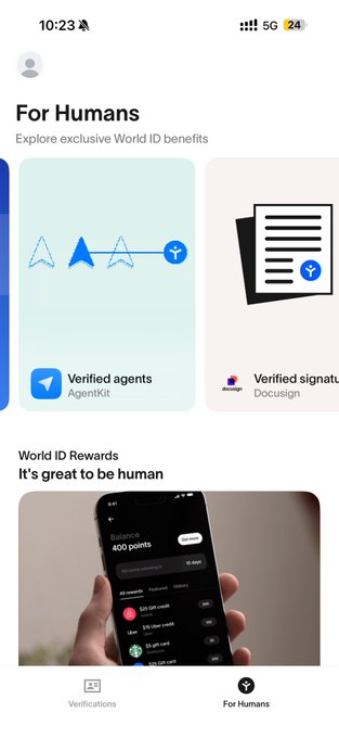 The image shows a person holding up their phone displaying an app called Agentkit, which is now available for beta testing. The app has been released as part of the World ID Rewards program, offering users exclusive benefits such as verified agents and verified signals. The image also includes text that reads "For humans Explore exclusive World ID benefits" and "It's great to be human".