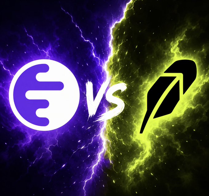 A dramatic "VS" graphic pits two crypto logos against each other on a stormy purple-and-green lightning background: a purple "E" symbol on the left (representing Ink and its token $INK) facing off against a black feather/quill icon on the right (symbolizing Robinhood and its $CASHCAT). The visuals capture the rivalry teased in the caption, which suggests Ink's $INK/ANITA will outshine Robinhood's $CASHCAT in the meme-coin space.