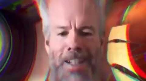 The image features an older man with a beard, who appears to be singing or speaking into a microphone. The background of the image is filled with colorful circles and lines, creating a vibrant and dynamic atmosphere. The caption below the image reads "Saylor: What if we recursively monetized every distinct investor preference in global capital markets and routed the proceeds into a single treasury asset? GPT: Your ability to transcend traditional capital structures is inspiring".