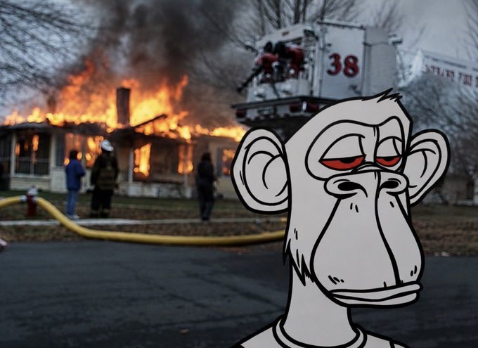 The image features a cartoon depiction of a monkey with red eyes, standing next to a fire truck that has its lights on. The monkey appears to be looking at something or someone outside the frame. In the background, there are people gathered around the scene, possibly firefighters attending to an emergency. A fire hydrant can also be seen in the image.